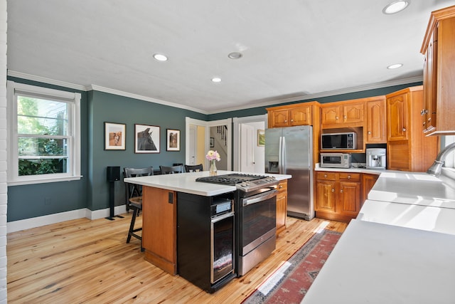 253 Quaker Meeting House Rd, Durham, ME 04222 - kitchen featuring stainless steel appliances, crown molding, a center island, light wood-style flooring, and light countertops