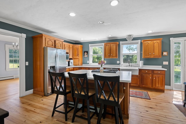 253 Quaker Meeting House Rd, Durham, ME 04222 - kitchen featuring stainless steel fridge, ornamental molding, light countertops, plenty of natural light, and a kitchen bar
