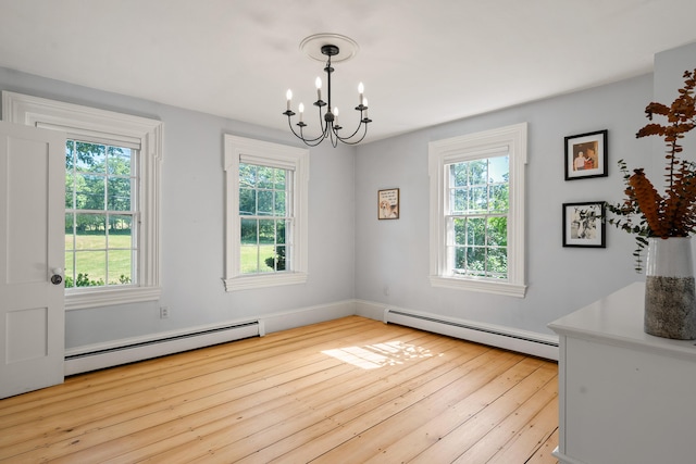 253 Quaker Meeting House Rd, Durham, ME 04222 - unfurnished dining area with baseboard heating, a chandelier, and hardwood / wood-style floors