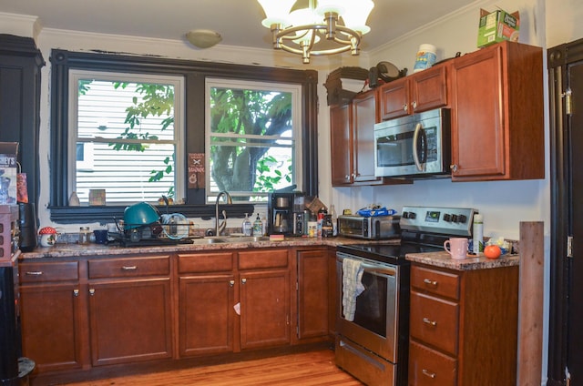 40 Chapel St, Augusta, ME 04330 - kitchen with stainless steel appliances, a chandelier, plenty of natural light, crown molding, and light wood-style floors