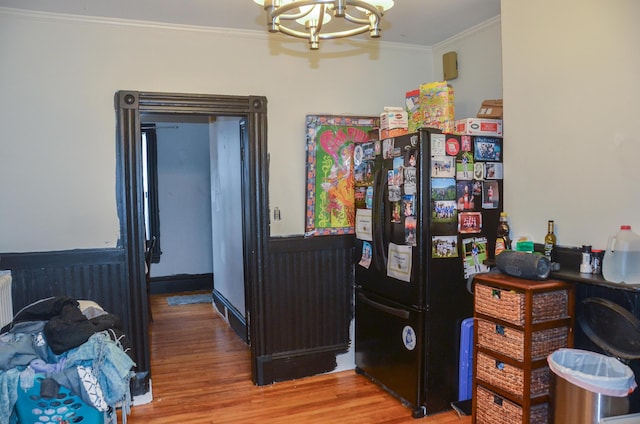 40 Chapel St, Augusta, ME 04330 - bedroom with freestanding refrigerator, a chandelier, crown molding, wood finished floors, and a wainscoted wall
