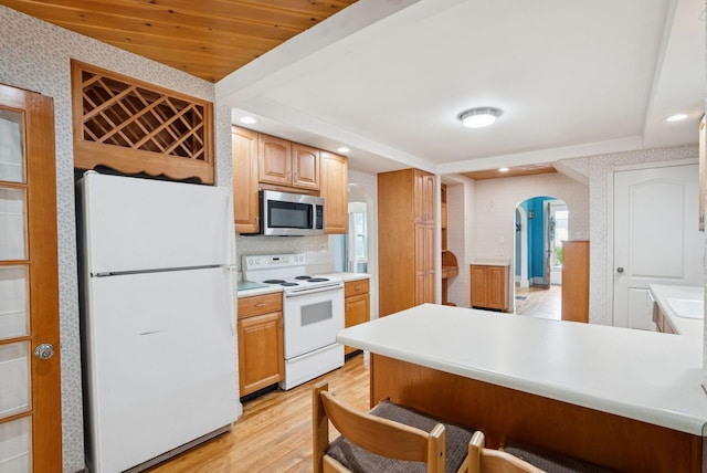 15 Huston Ave, Auburn, ME 04210 - kitchen with white appliances, arched walkways, light wood-style flooring, wallpapered walls, and a breakfast bar area
