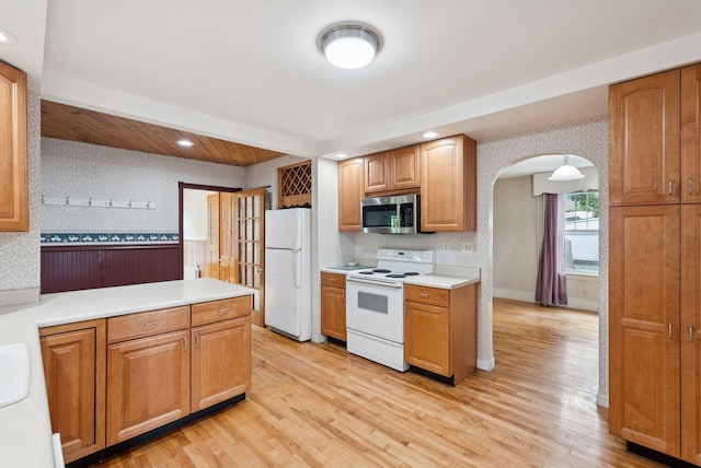 15 Huston Ave, Auburn, ME 04210 - kitchen featuring white appliances, wallpapered walls, arched walkways, light countertops, and light wood finished floors