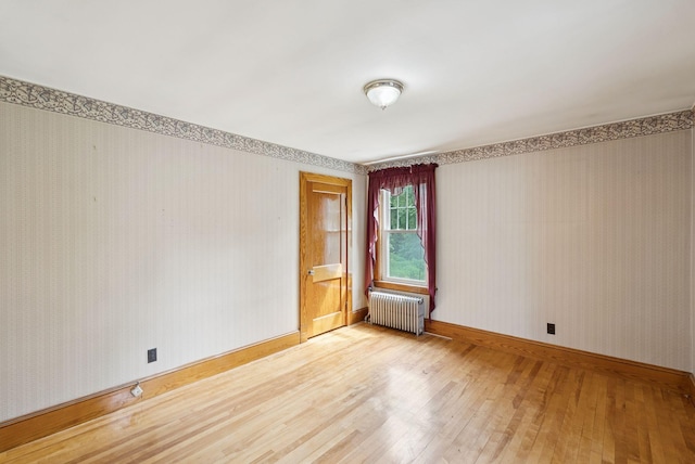 15 Huston Ave, Auburn, ME 04210 - unfurnished room with radiator heating unit, hardwood / wood-style flooring, and wallpapered walls