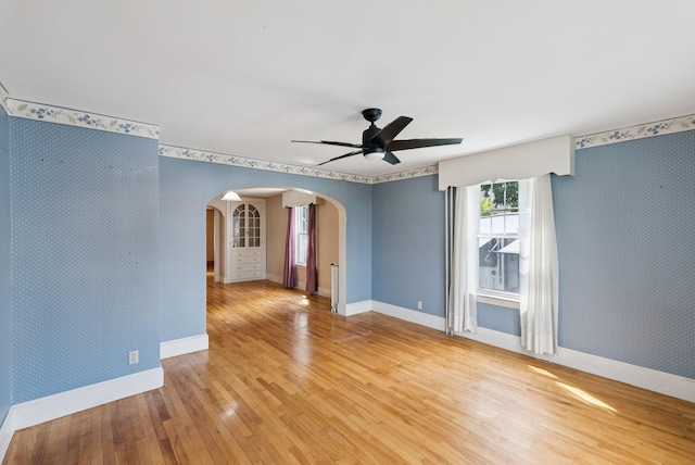 15 Huston Ave, Auburn, ME 04210 - spare room with arched walkways, wallpapered walls, light wood-type flooring, and a ceiling fan