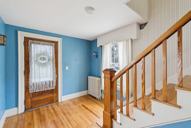 15 Huston Ave, Auburn, ME 04210 - foyer entrance featuring radiator heating unit, wood finished floors, and stairway