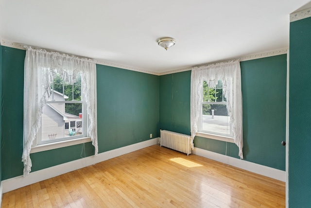 15 Huston Ave, Auburn, ME 04210 - spare room with radiator heating unit, wood-type flooring, and plenty of natural light