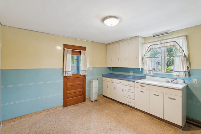 15 Huston Ave, Auburn, ME 04210 - kitchen featuring radiator, plenty of natural light, and white cabinetry