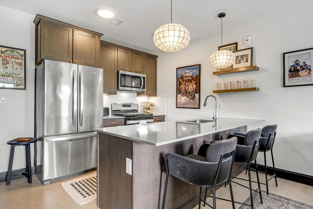 218 Washington Ave Unit 408, Portland, ME 04101 - kitchen with appliances with stainless steel finishes, a kitchen breakfast bar, light wood-type flooring, pendant lighting, and open shelves