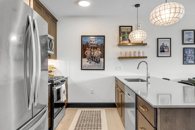 218 Washington Ave Unit 408, Portland, ME 04101 - kitchen with stainless steel appliances, light wood-type flooring, a peninsula, light countertops, and pendant lighting
