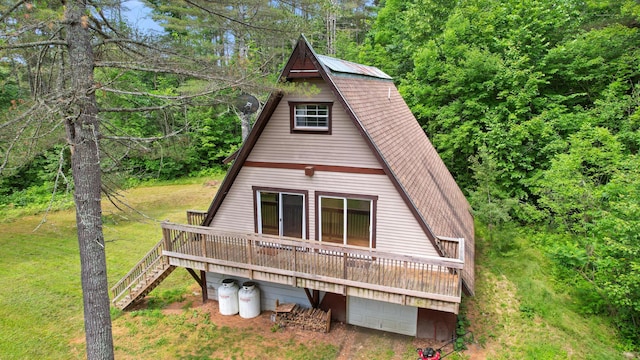 36 Palmer Rd, Etna, ME 04434 - rear view of property featuring a garage, a deck, stairs, and a lawn