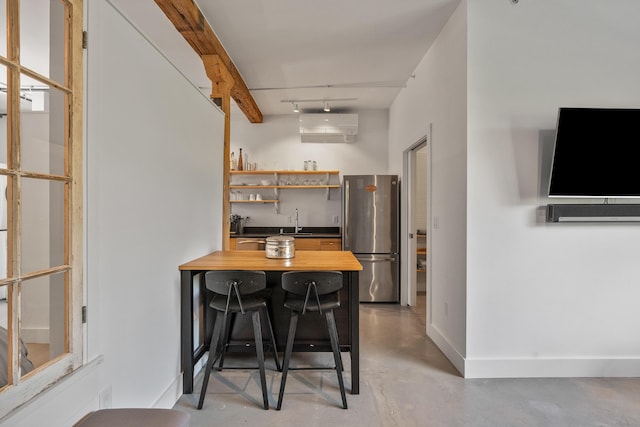 273 Congress St Unit 1, Portland, ME 04101 - kitchen with freestanding refrigerator, wood counters, concrete floors, open shelves, and a peninsula