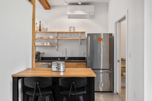 273 Congress St Unit 1, Portland, ME 04101 - kitchen with appliances with stainless steel finishes, wood counters, a breakfast bar area, and a peninsula