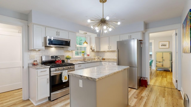 11 Southern Ave, Augusta, ME 04330 - kitchen with appliances with stainless steel finishes, light wood-style flooring, a chandelier, and decorative backsplash