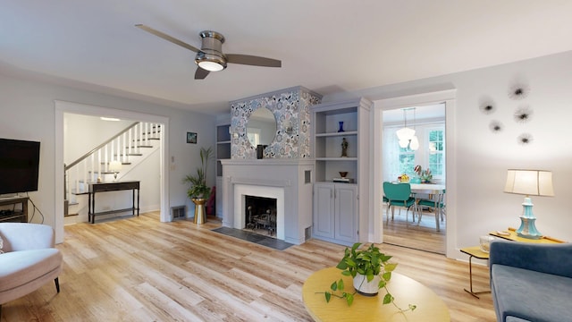 11 Southern Ave, Augusta, ME 04330 - living area featuring stairs, ceiling fan, light wood-style floors, and a fireplace with flush hearth
