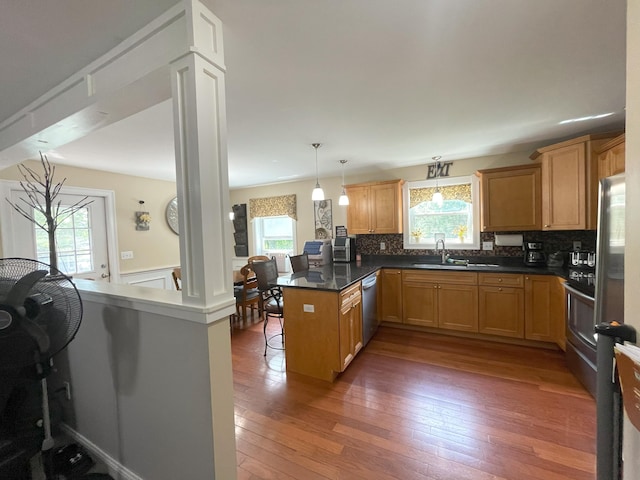 28 Kayla Way, Gorham, ME 04038 - kitchen featuring a peninsula, decorative backsplash, hardwood / wood-style floors, a breakfast bar area, and decorative light fixtures