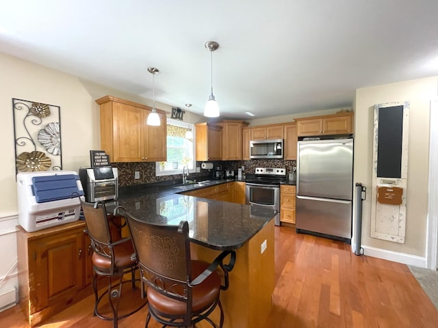 28 Kayla Way, Gorham, ME 04038 - kitchen featuring stainless steel appliances, a peninsula, tasteful backsplash, and hanging light fixtures