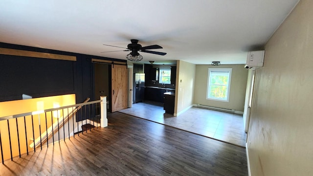 28 Kayla Way, Gorham, ME 04038 - empty room with a baseboard radiator, a barn door, wood finished floors, and a ceiling fan