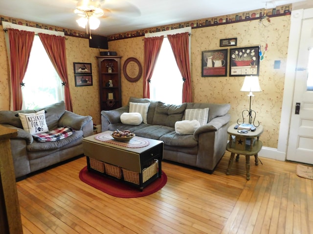 10 Liberty St, Dexter, ME 04930 - living area featuring wallpapered walls, healthy amount of natural light, a ceiling fan, and hardwood / wood-style floors