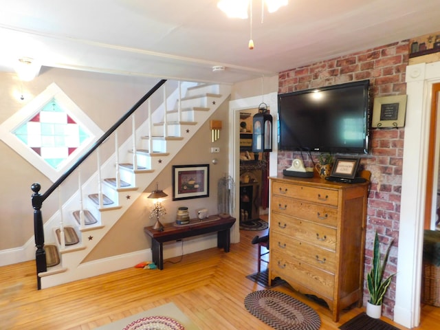 10 Liberty St, Dexter, ME 04930 - living room with stairs, wood finished floors, and brick wall