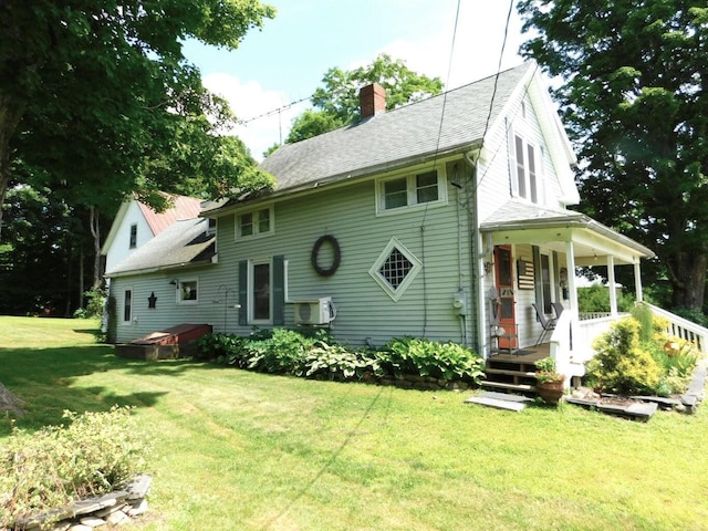 10 Liberty St, Dexter, ME 04930 - view of front of home with a chimney, a front yard, covered porch, and a shingled roof