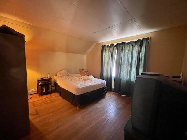 322 Katahdin Ave, Millinocket, ME 04462 - bedroom featuring wood finished floors, vaulted ceiling, and a baseboard heating unit