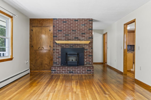 232 Augusta Rd, Topsham, ME 04086 - unfurnished living room with baseboard heating, wood finished floors, and a fireplace
