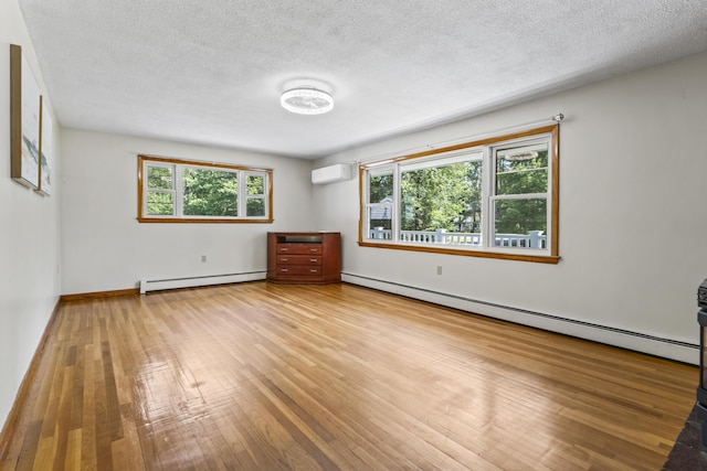 232 Augusta Rd, Topsham, ME 04086 - unfurnished room with a baseboard heating unit, hardwood / wood-style flooring, a textured ceiling, and a wall mounted AC