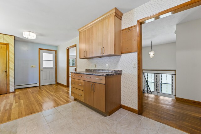 232 Augusta Rd, Topsham, ME 04086 - kitchen with a baseboard heating unit, light wood-style floors, wallpapered walls, and dark stone counters