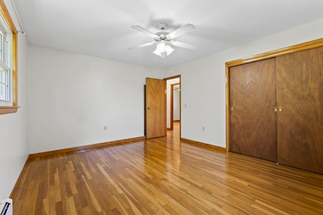 232 Augusta Rd, Topsham, ME 04086 - unfurnished bedroom with a baseboard radiator, light wood-type flooring, a closet, and ceiling fan