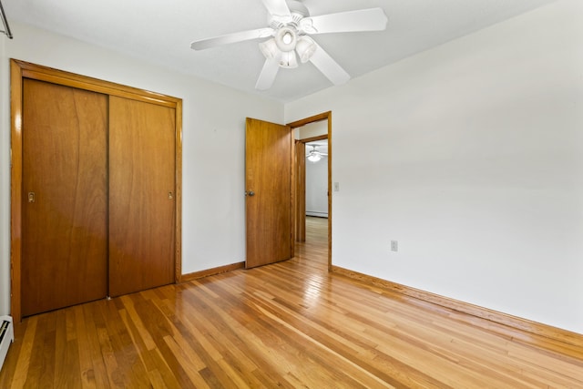 232 Augusta Rd, Topsham, ME 04086 - unfurnished bedroom featuring light wood finished floors, a closet, baseboard heating, and a baseboard heating unit
