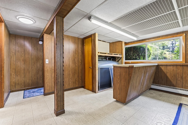 232 Augusta Rd, Topsham, ME 04086 - kitchen with wooden walls, baseboard heating, washer / clothes dryer, a peninsula, and brown cabinets