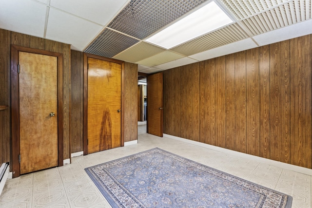 232 Augusta Rd, Topsham, ME 04086 - hallway featuring wood walls, a paneled ceiling, and a baseboard heating unit