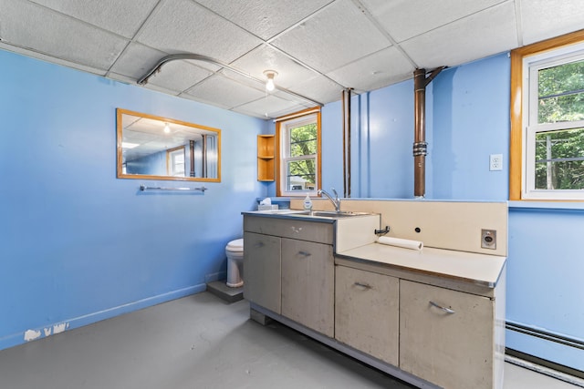 232 Augusta Rd, Topsham, ME 04086 - bathroom with a drop ceiling, a baseboard heating unit, vanity, finished concrete flooring, and plenty of natural light
