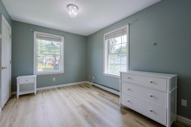 18 Wilson Dr, Westbrook, ME 04092 - unfurnished bedroom featuring a baseboard heating unit, multiple windows, and light wood-style floors