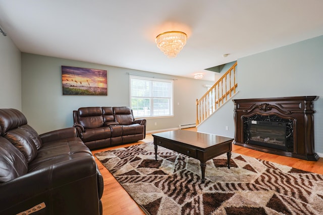 18 Wilson Dr, Westbrook, ME 04092 - living area featuring stairs, a baseboard heating unit, wood finished floors, a glass covered fireplace, and a chandelier
