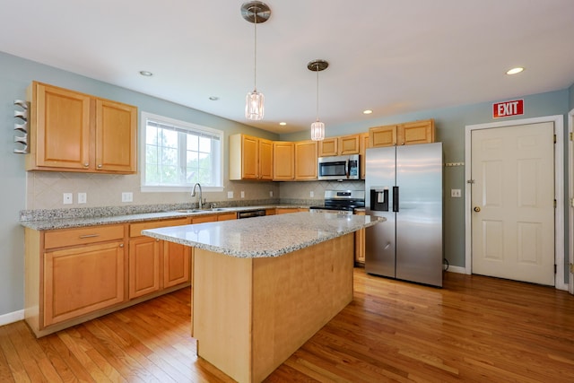 18 Wilson Dr, Westbrook, ME 04092 - kitchen with appliances with stainless steel finishes, light wood finished floors, a kitchen island, tasteful backsplash, and light stone counters