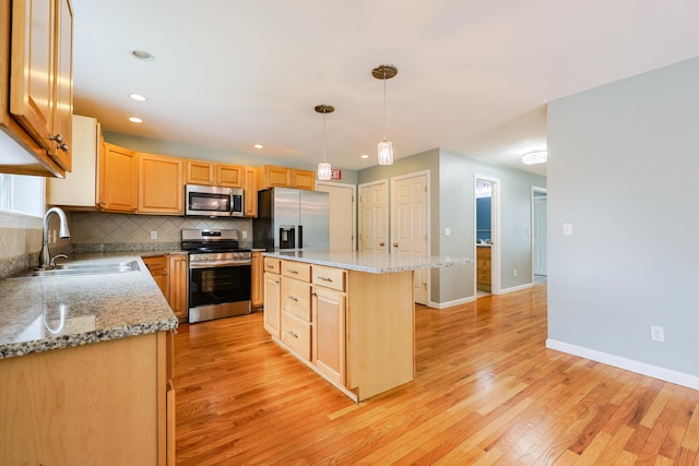 18 Wilson Dr, Westbrook, ME 04092 - kitchen with appliances with stainless steel finishes, light wood-style flooring, tasteful backsplash, a center island, and light brown cabinets