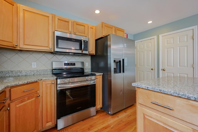 18 Wilson Dr, Westbrook, ME 04092 - kitchen with stainless steel appliances, light wood finished floors, decorative backsplash, light stone countertops, and recessed lighting