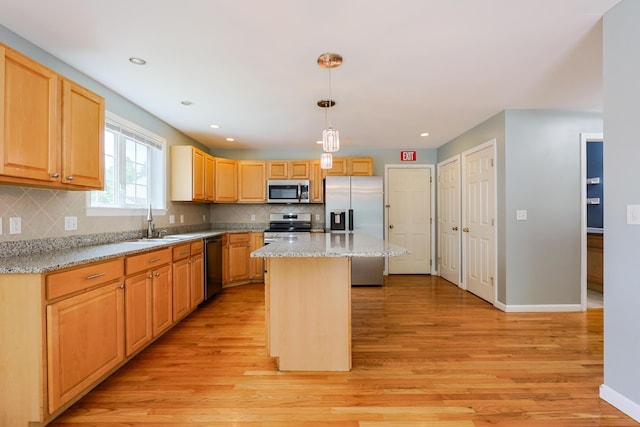 18 Wilson Dr, Westbrook, ME 04092 - kitchen featuring stainless steel appliances, light wood finished floors, backsplash, a center island, and light stone counters