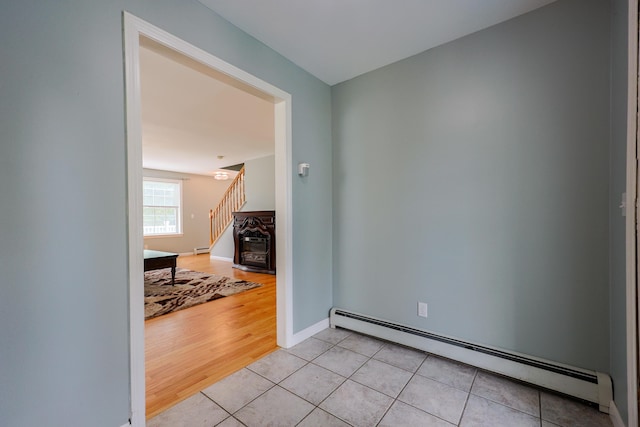 18 Wilson Dr, Westbrook, ME 04092 - unfurnished room featuring a baseboard heating unit, light tile patterned floors, and stairs