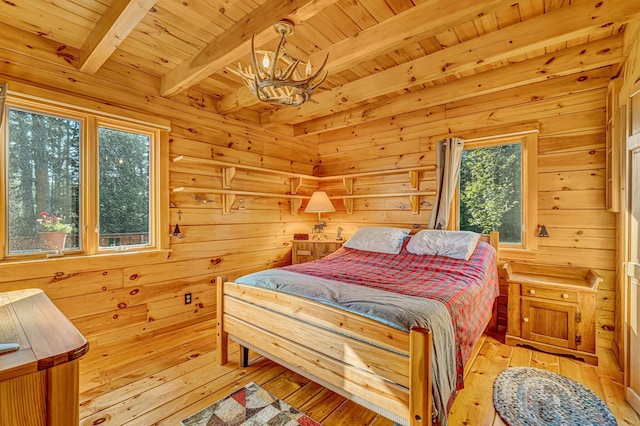 642 Mingo Loop Rd, Rangeley, ME 04970 - bedroom featuring a chandelier, a wooden ceiling with exposed beams, wooden walls, and light wood finished floors