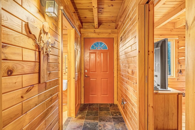 642 Mingo Loop Rd, Rangeley, ME 04970 - entryway with a wooden ceiling with exposed beams, wood walls, and dark stone finish floors