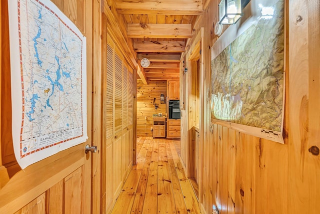 642 Mingo Loop Rd, Rangeley, ME 04970 - corridor with wood walls and light wood-style floors