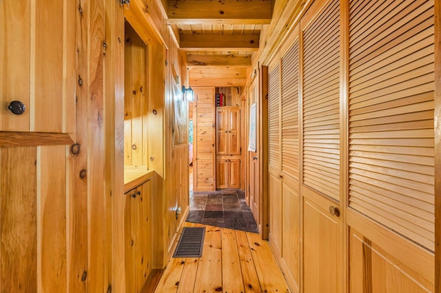 642 Mingo Loop Rd, Rangeley, ME 04970 - hallway with wooden walls, light wood-style flooring, and a wooden ceiling with exposed beams