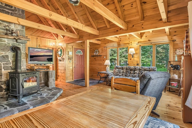 642 Mingo Loop Rd, Rangeley, ME 04970 - dining space featuring wooden walls, hardwood / wood-style floors, a wooden ceiling with exposed beams, a wood stove, and high vaulted ceiling