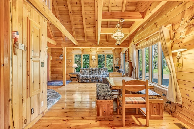642 Mingo Loop Rd, Rangeley, ME 04970 - dining area featuring a wood ceiling with exposed beams, wooden walls, and light wood-style flooring