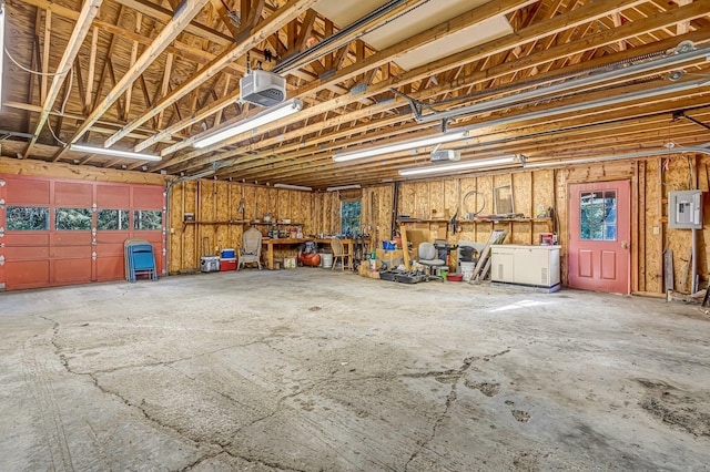 642 Mingo Loop Rd, Rangeley, ME 04970 - garage featuring electric panel, a garage door opener, and a workshop area