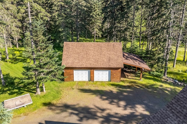 642 Mingo Loop Rd, Rangeley, ME 04970 - garage featuring a forest view and driveway