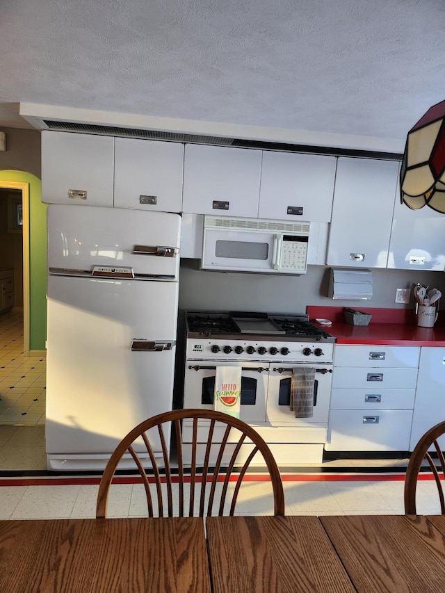 69 Scott Dr, Monmouth, ME 04259 - kitchen with white appliances, white cabinetry, a textured ceiling, and arched walkways